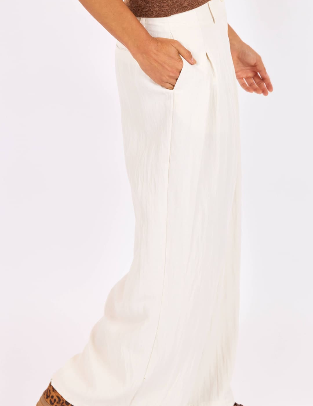 White wide-leg trousers with a high waist and front pockets, made from a soft, flowing fabric.