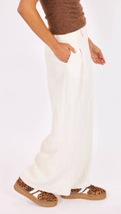 White wide-leg trousers with a high waist and front pockets, made from a soft, flowing fabric.