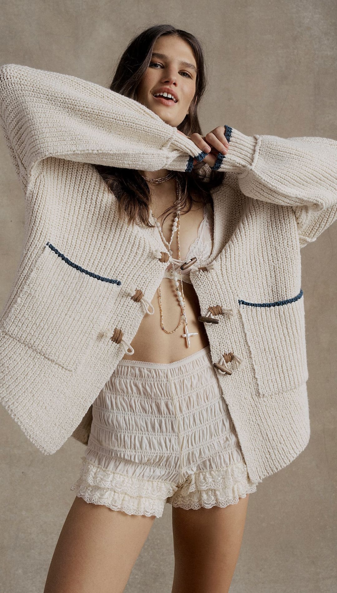 White textured blazer with black piping and toggle closures.