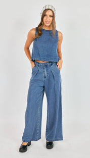 Blue denim sleeveless crop top with a frayed hem and subtle distressing.