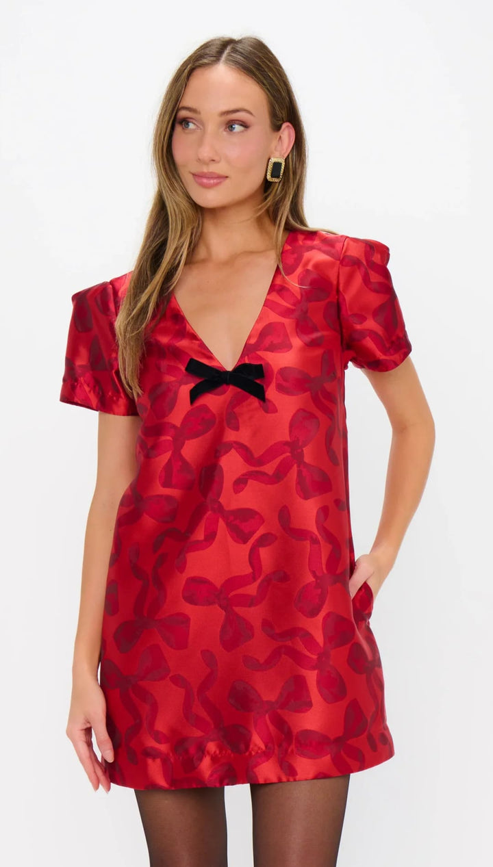 Red satin dress with black bow and floral pattern, inspired by vintage fashion.