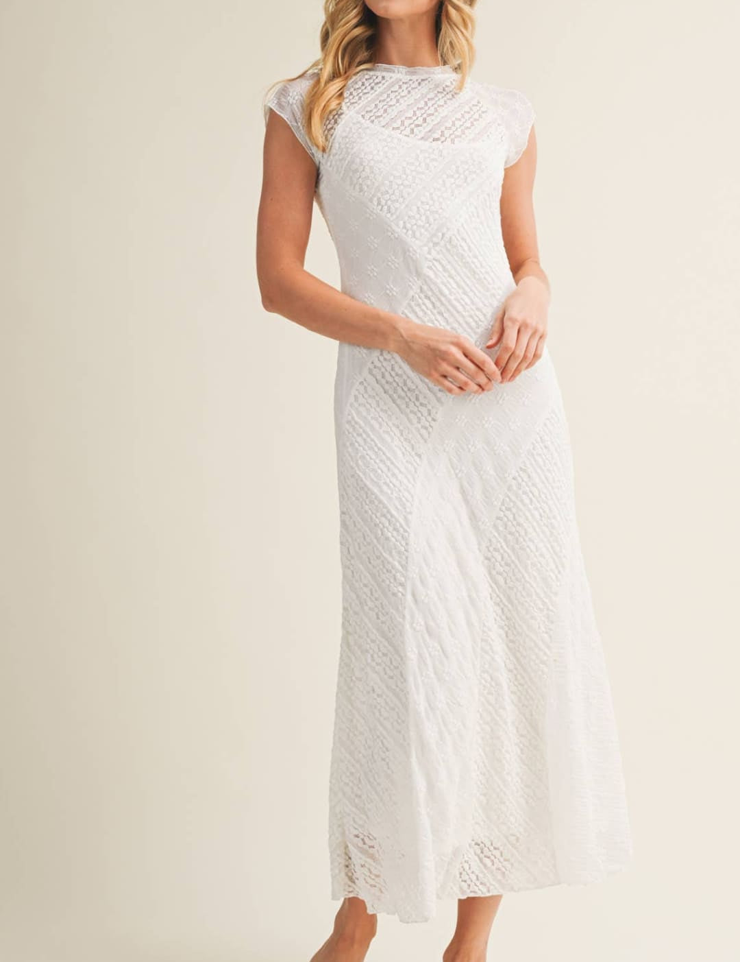 A white lace midi dress with a fitted bodice and flowing skirt.