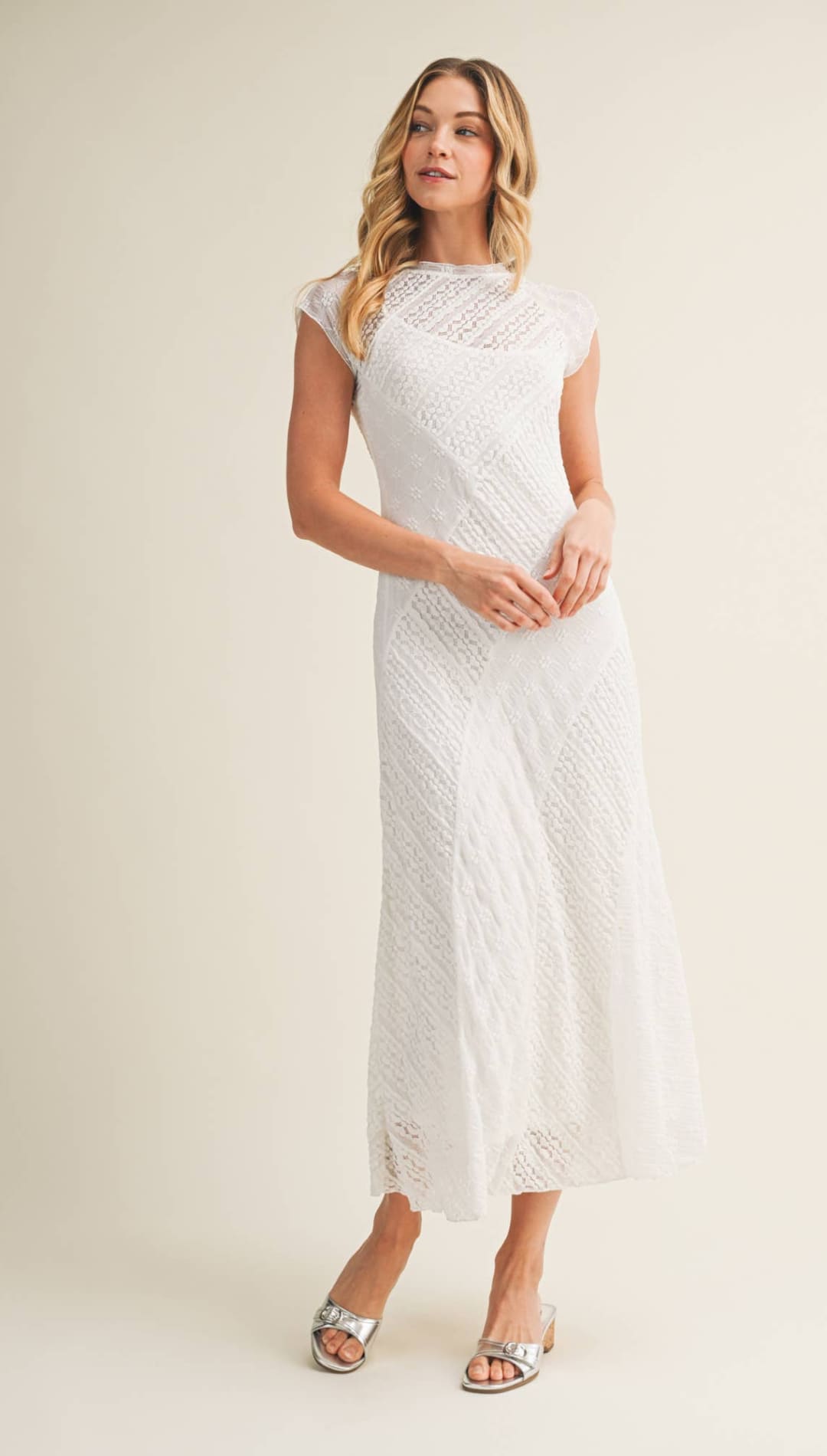 A white lace midi dress with a fitted bodice and flowing skirt.