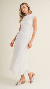 A flowing white lace maxi dress with a fitted bodice and flared skirt.
