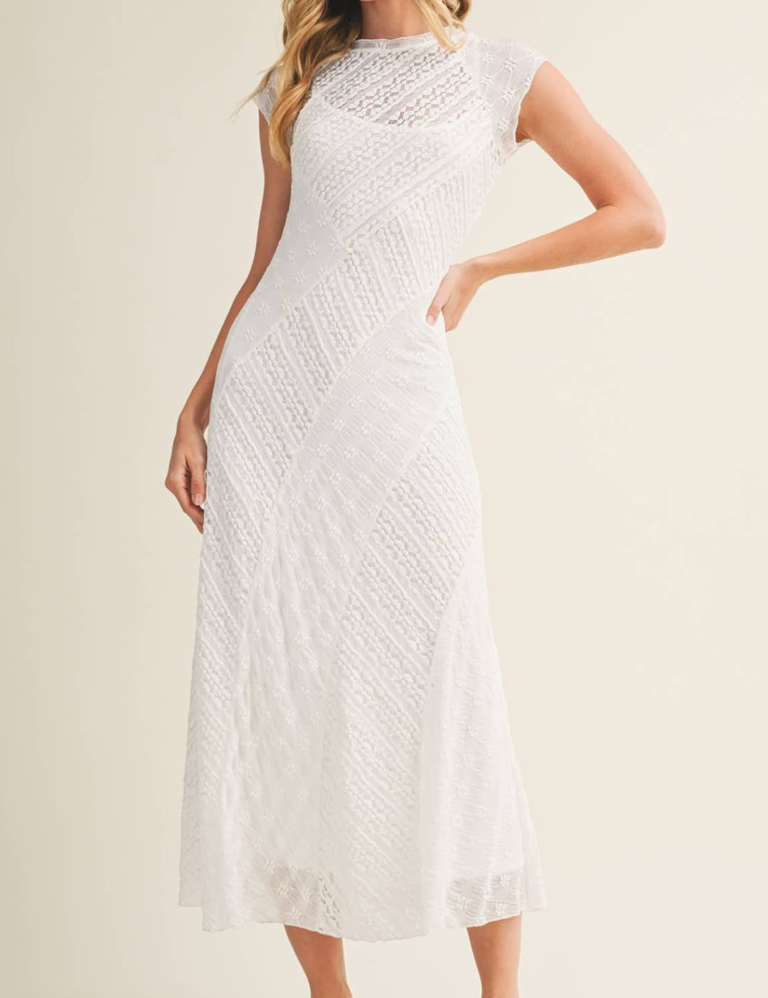 A white lace midi dress with a fitted bodice and flowing skirt.