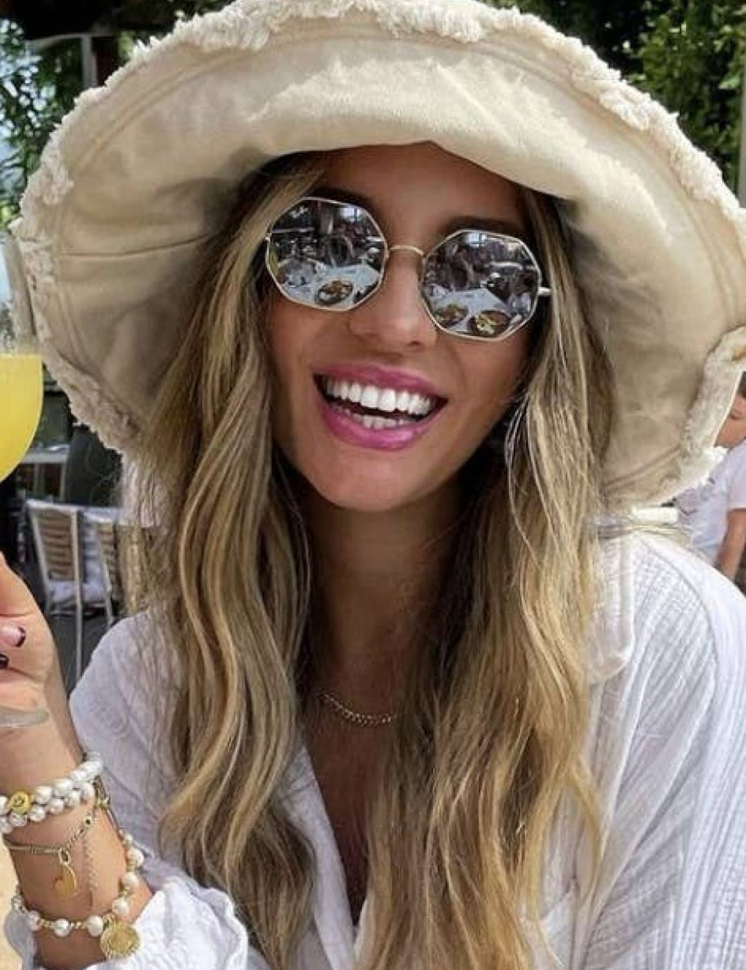 Smiling woman in a floppy hat and sunglasses.