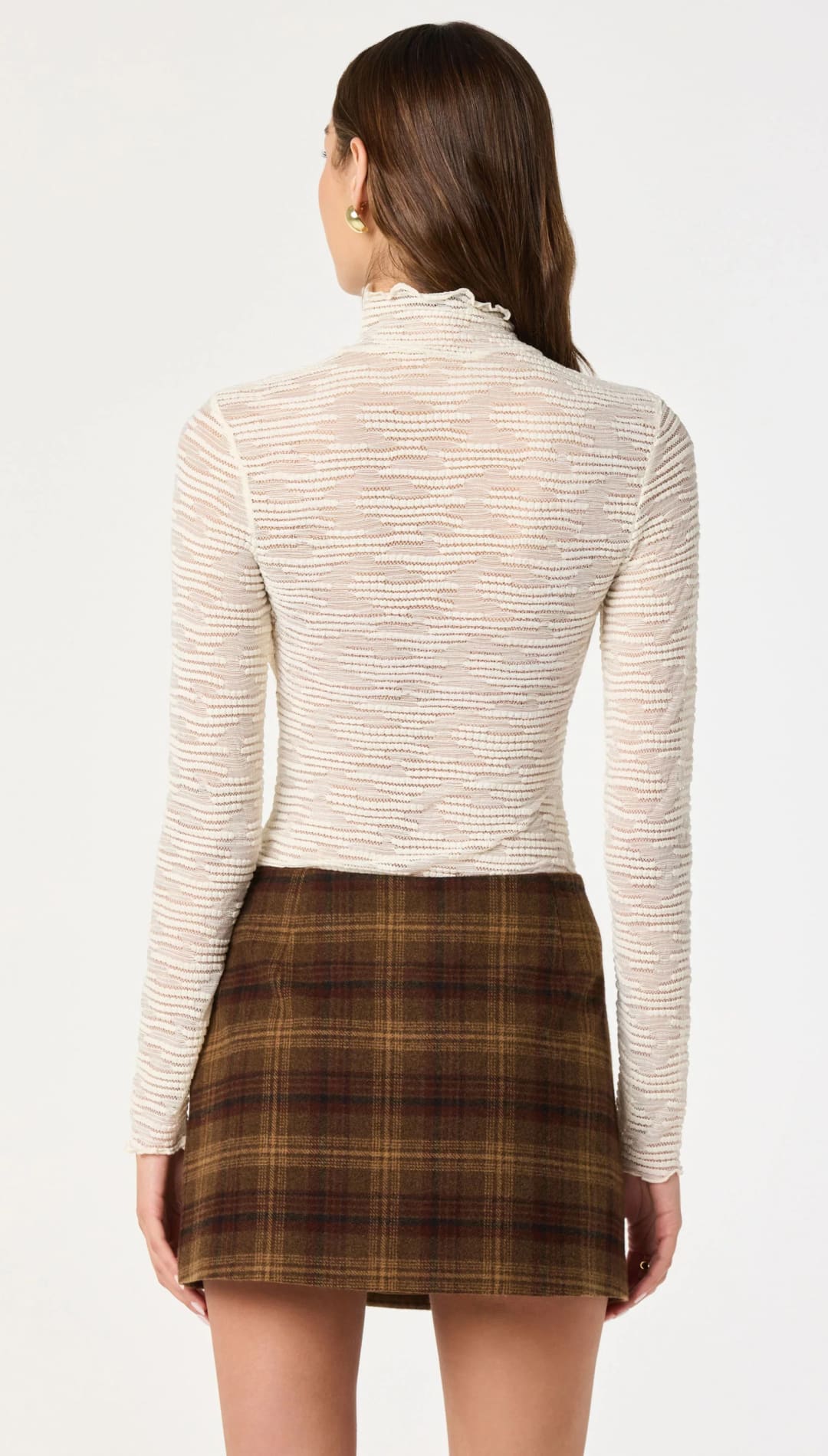 A cream-colored, long-sleeved turtleneck top with a subtle textured weave.