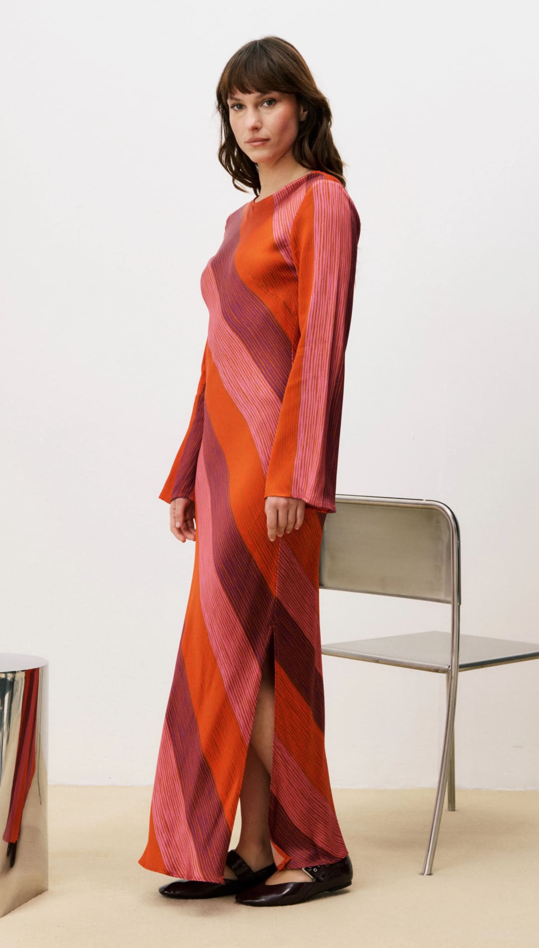 Pink and orange striped maxi dress with long sleeves, likely made of silk or satin.