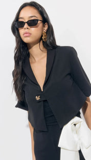 Black cropped blazer with a single gold-tone embellishment.