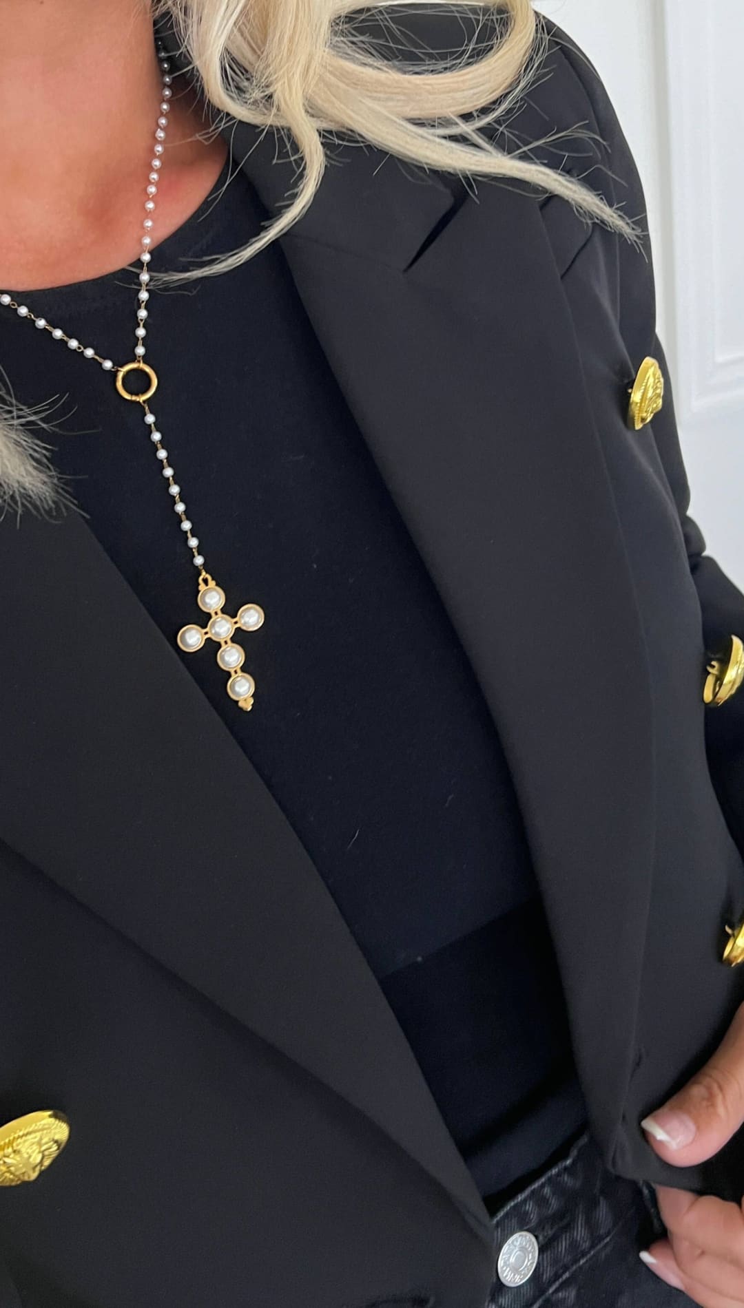 Gold-toned cross pendant necklace with a delicate chain and pearl accents.