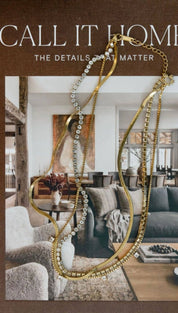 Gold-toned layered necklace with sparkling diamond-like stones and a delicate chain design.