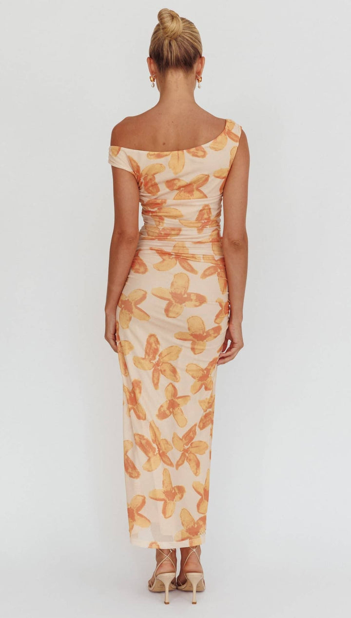 A woman wears an off-the-shoulder, form-fitting midi dress with a cream base and orange floral pattern.