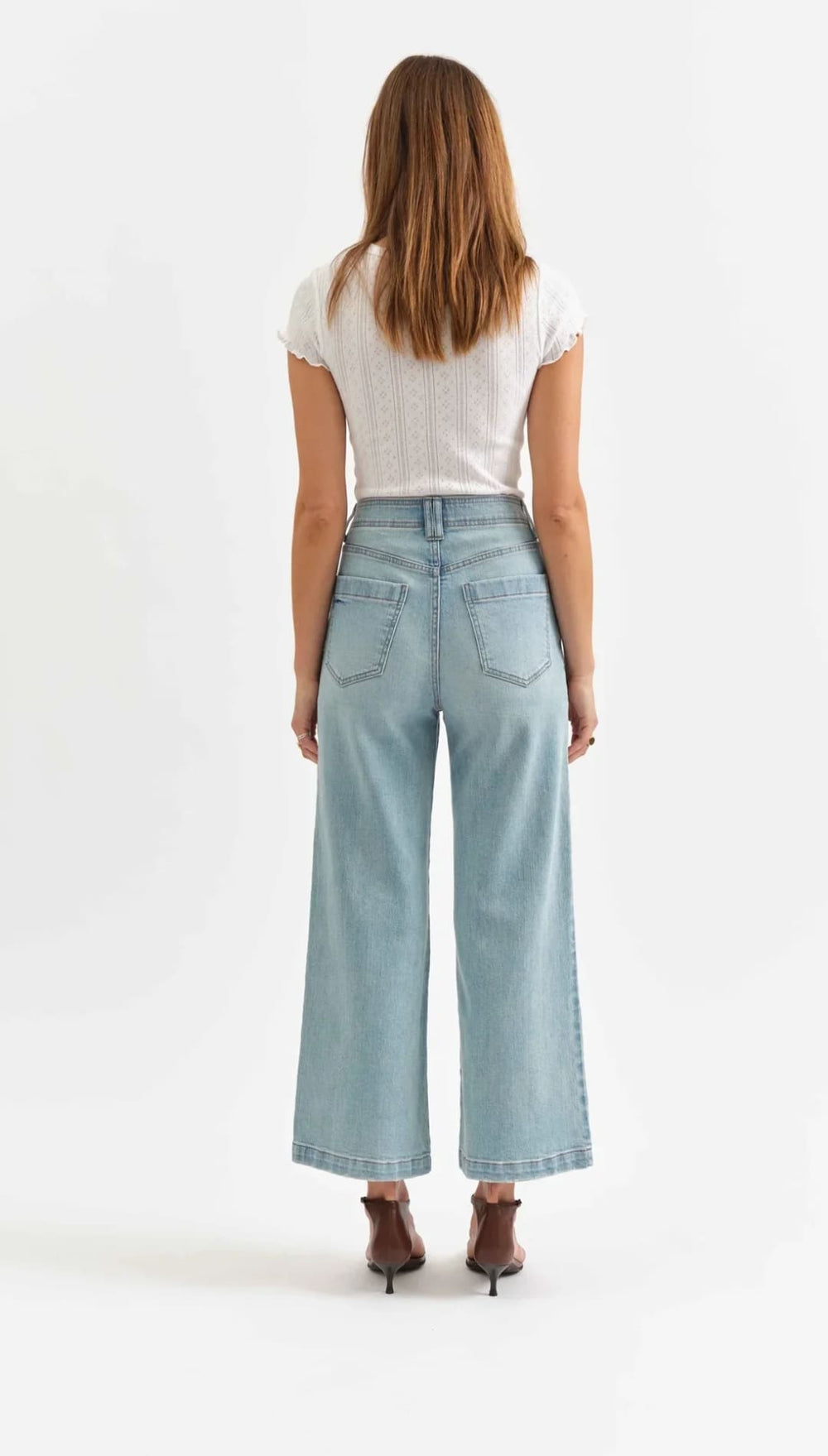 Light blue wide-leg jeans paired with a white t-shirt and brown heels.