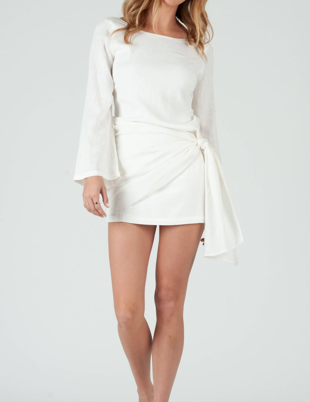 White wrap-style mini dress with long bell sleeves.