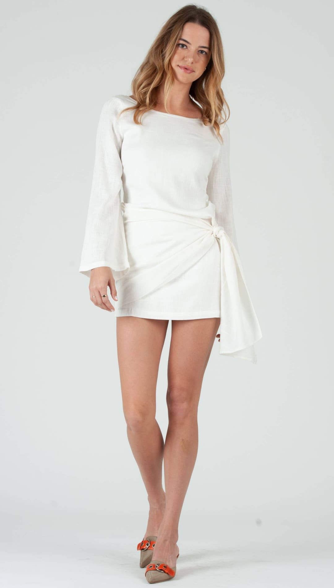 White wrap-style mini dress with long bell sleeves.