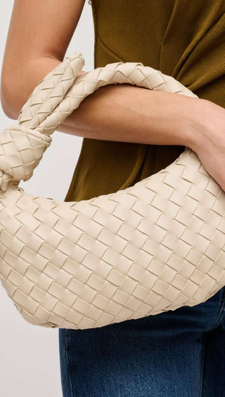 Woven cream-colored leather handbag with knotted handle.