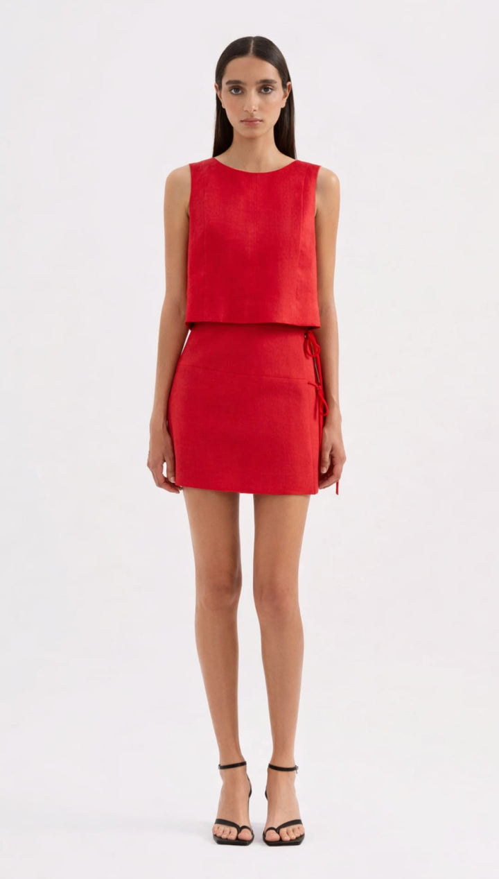 A vibrant red sleeveless mini dress with a structured bodice and skirt, featuring side ties for adjustable fit.