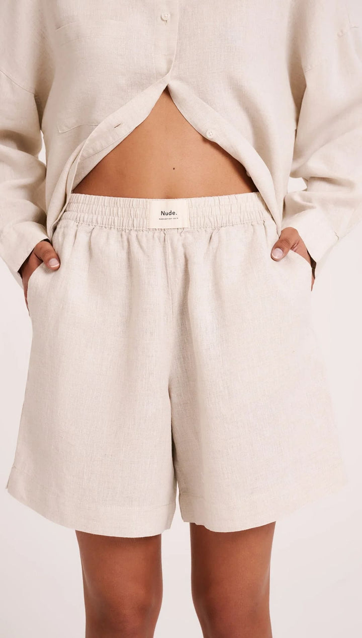 Beige linen shorts with elastic waistband.