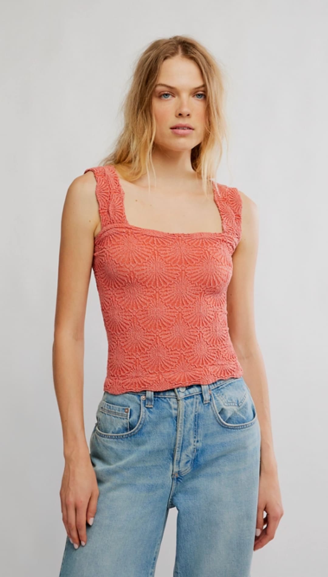 Coral-colored lace tank top with a square neckline and delicate floral pattern