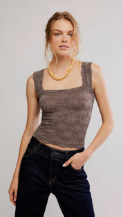 A taupe-colored, sleeveless crop top with a square neckline and an intricate geometric pattern.