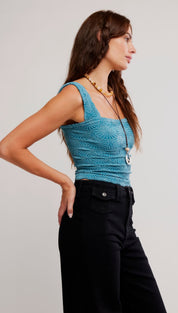 A teal, textured crochet crop top with square neckline and thin straps.