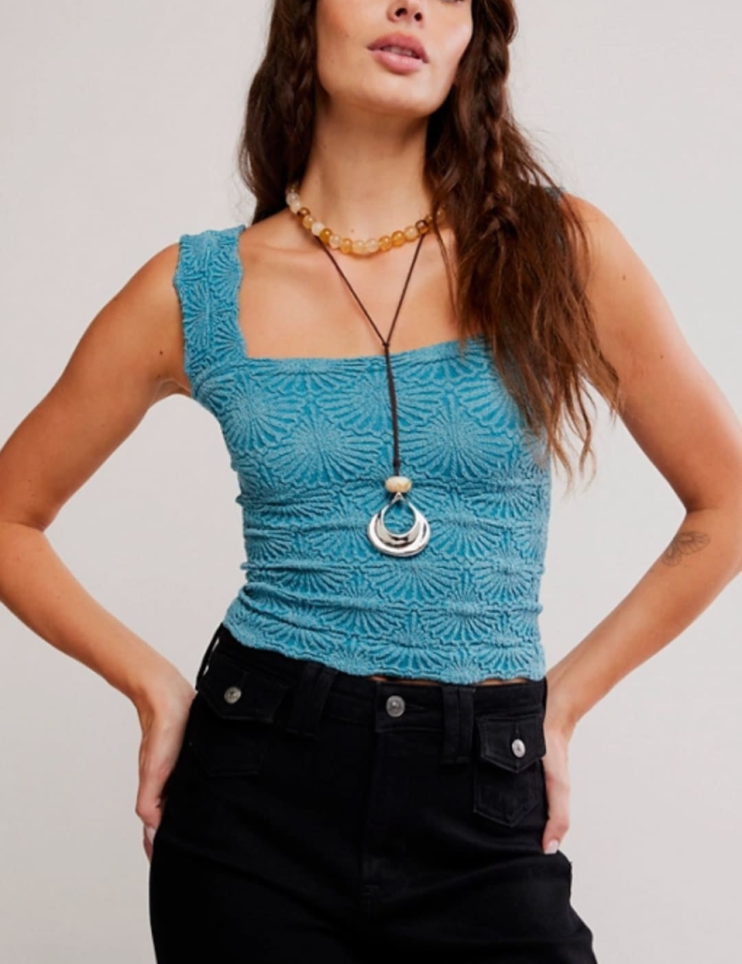 A turquoise lace crop top with a square neckline and intricate floral embroidery.