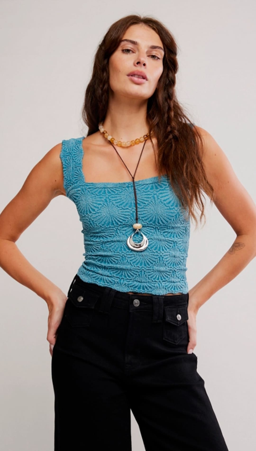A turquoise lace crop top with a square neckline and intricate floral embroidery.