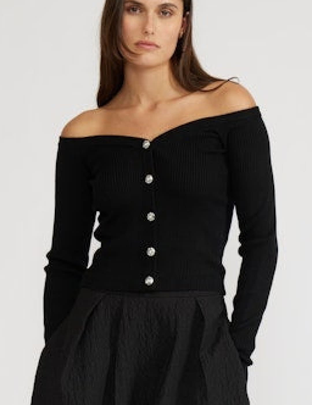 Black off-the-shoulder sweater with buttons down the front.