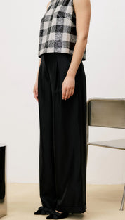 Black wide-leg trousers with a high waist and pleats, likely made of cotton or linen.