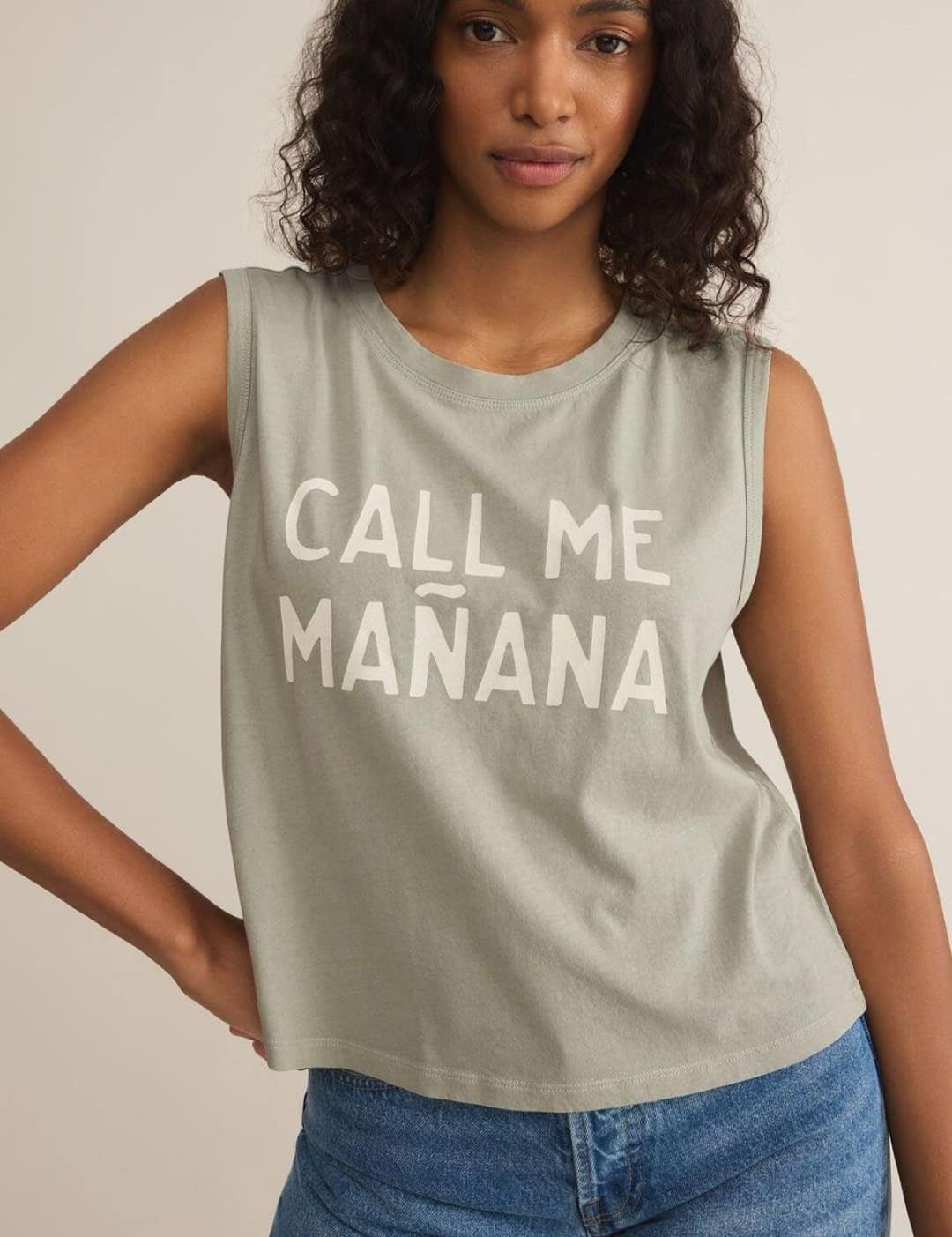 Woman wearing a sleeveless shirt and denim shorts.