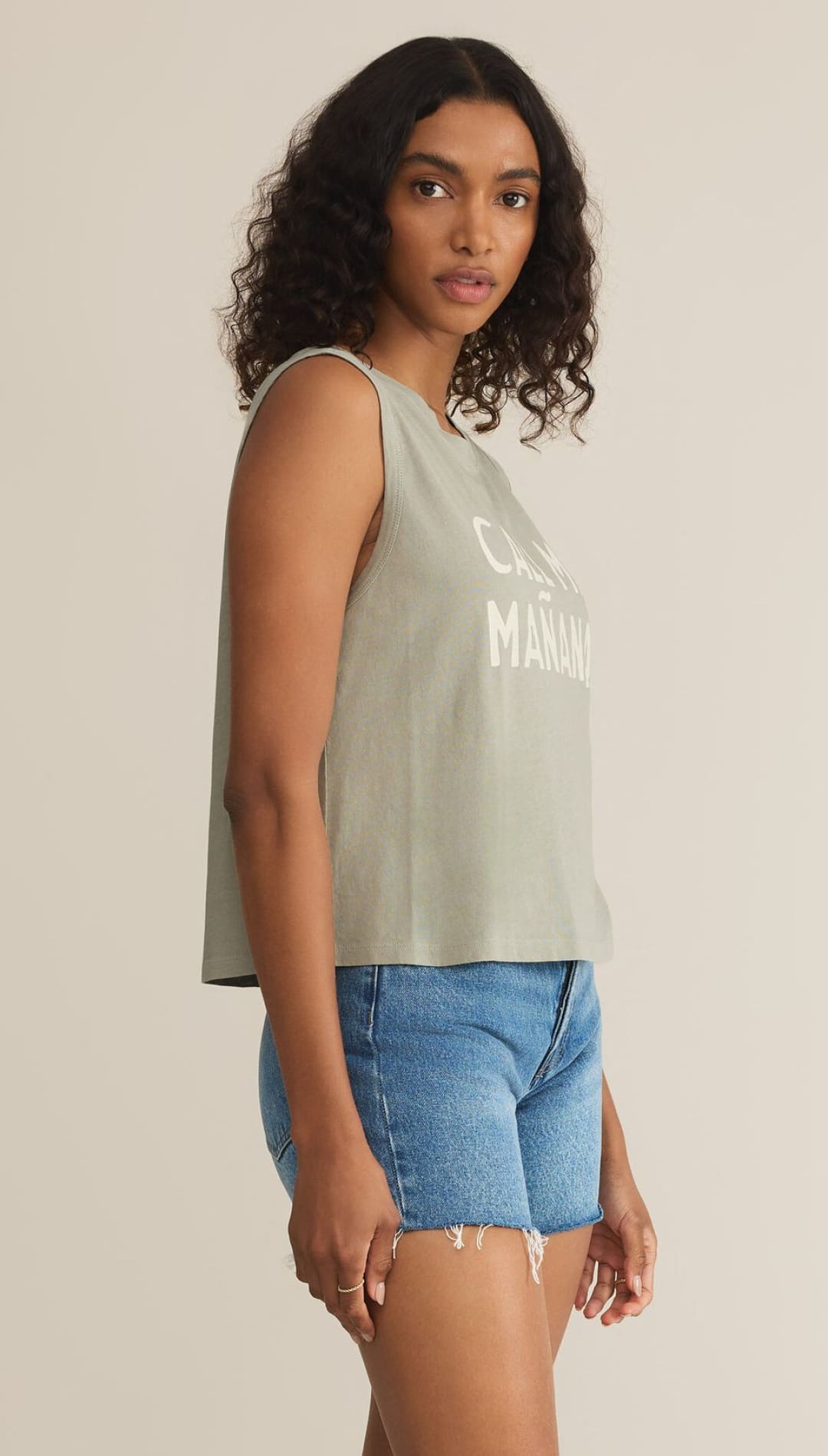 Woman’s green tank top and denim shorts.