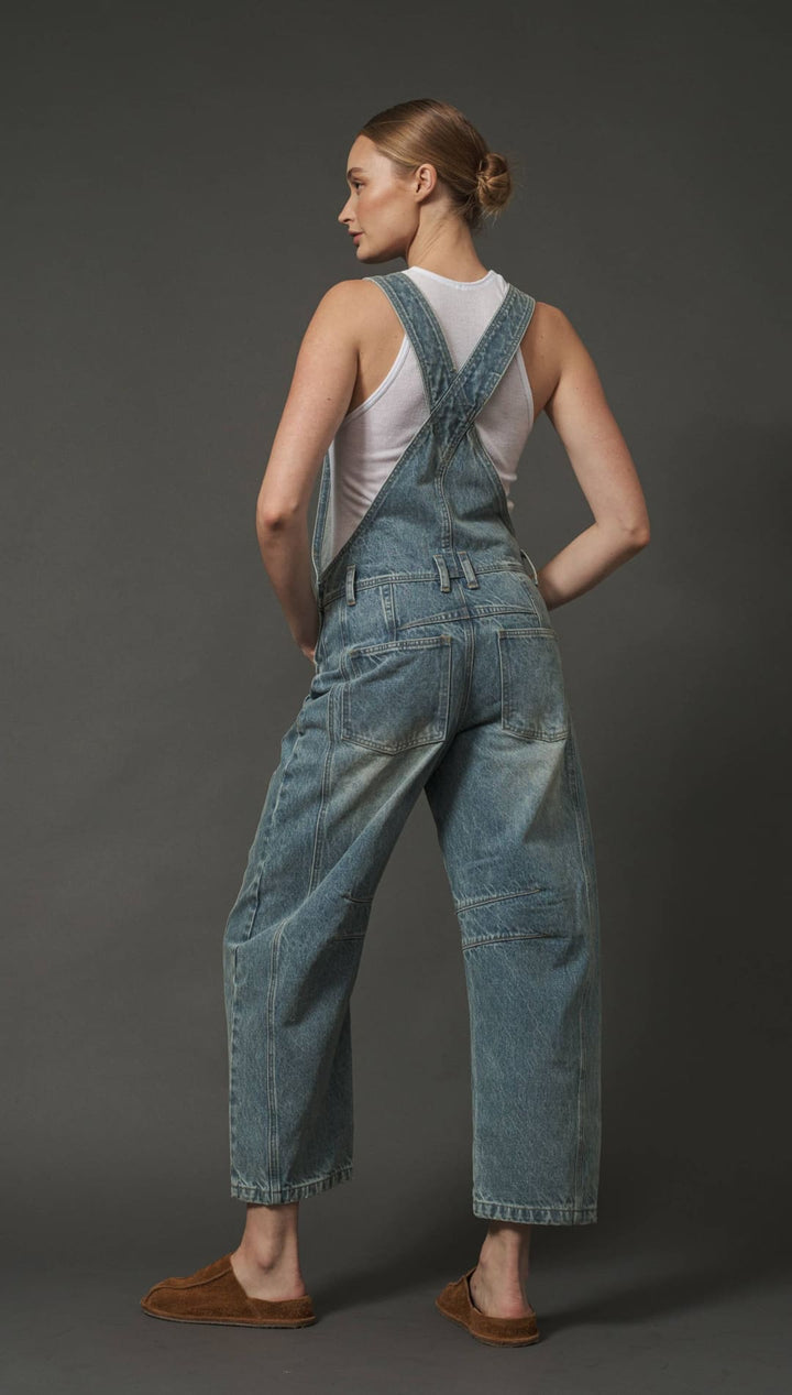 Denim overalls with adjustable straps and pockets, light blue wash.