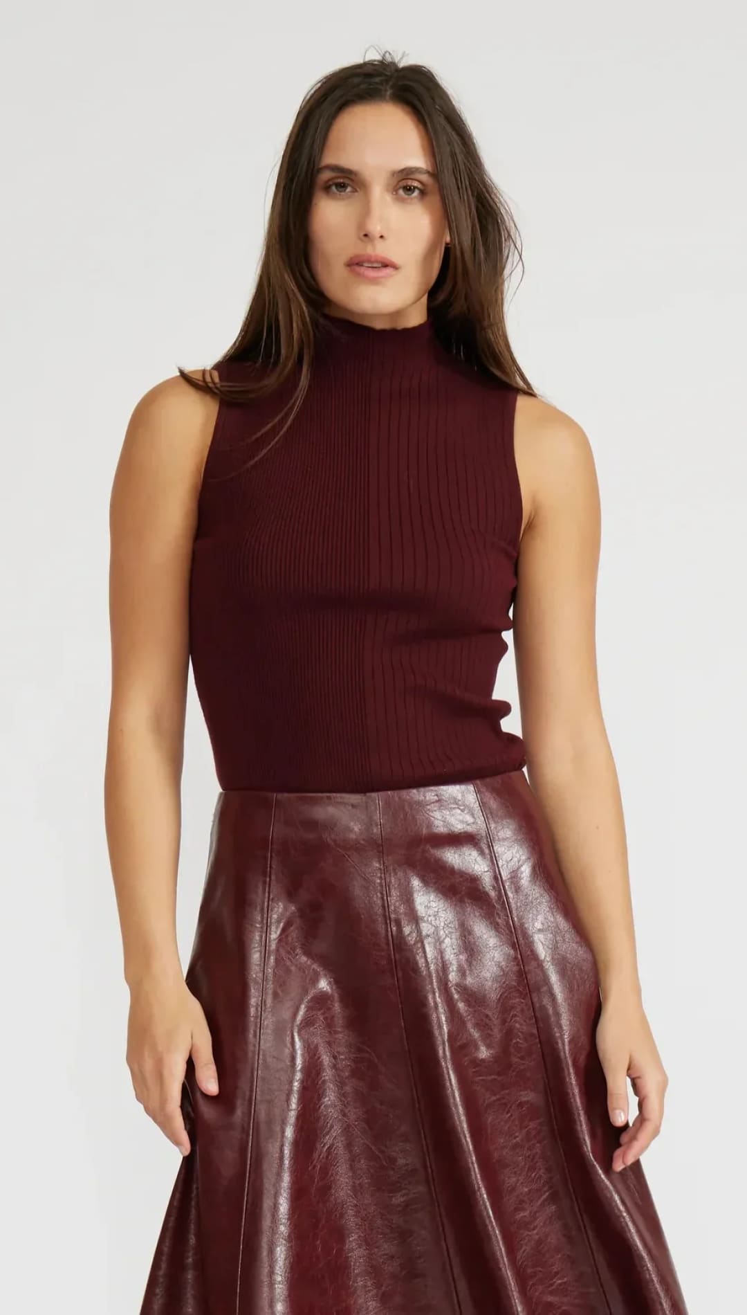 A maroon sleeveless ribbed knit mock-neck top.