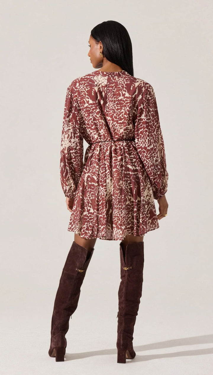 Woman’s patterned long-sleeved dress with thigh-high boots.