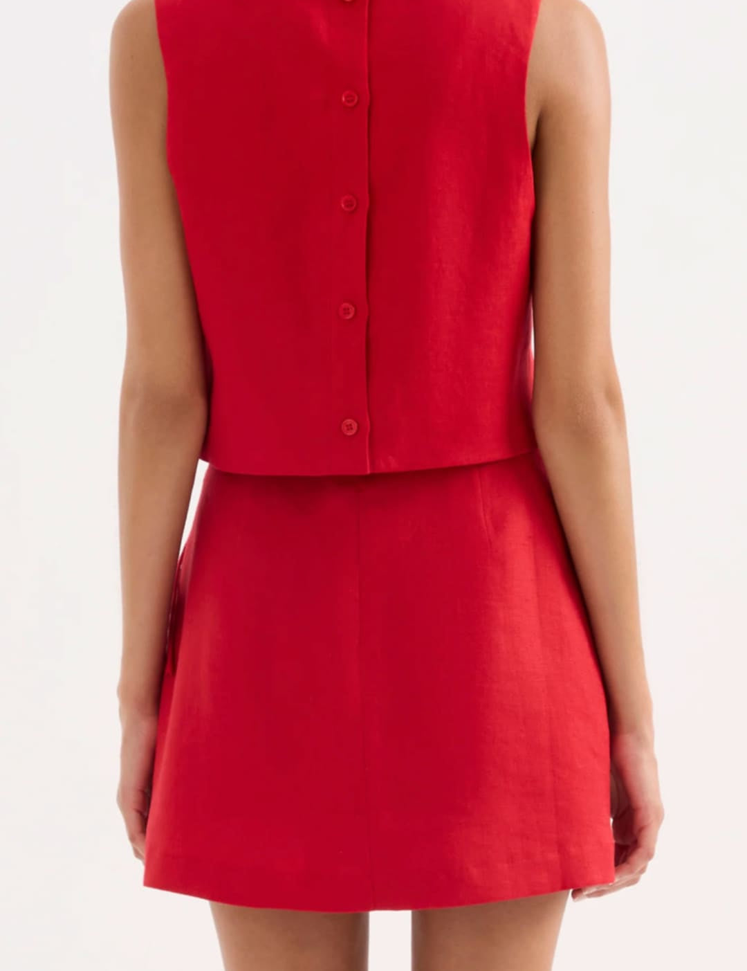 A vibrant red sleeveless dress with a buttoned back and flared skirt.