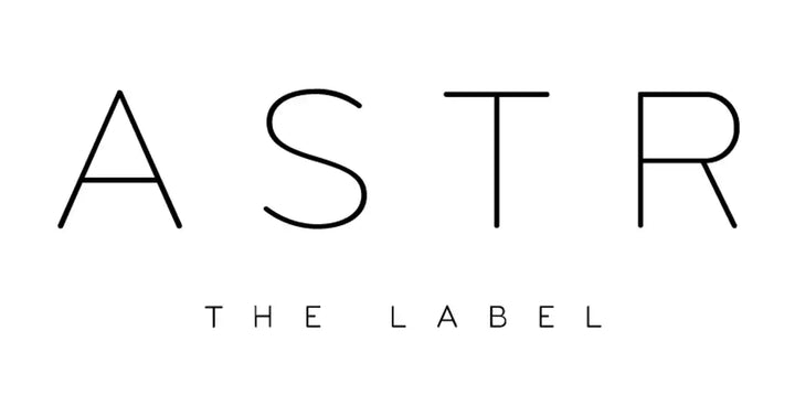 Minimalist black text logo spelling ’ASTR THE LABEL’ in thin capital letters.