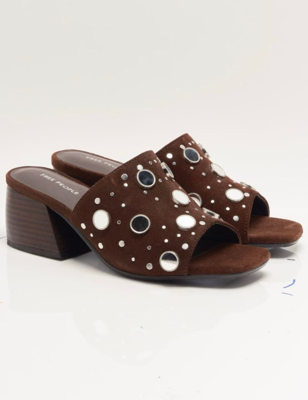 Brown leather mule sandals with eyelet details and block heel.