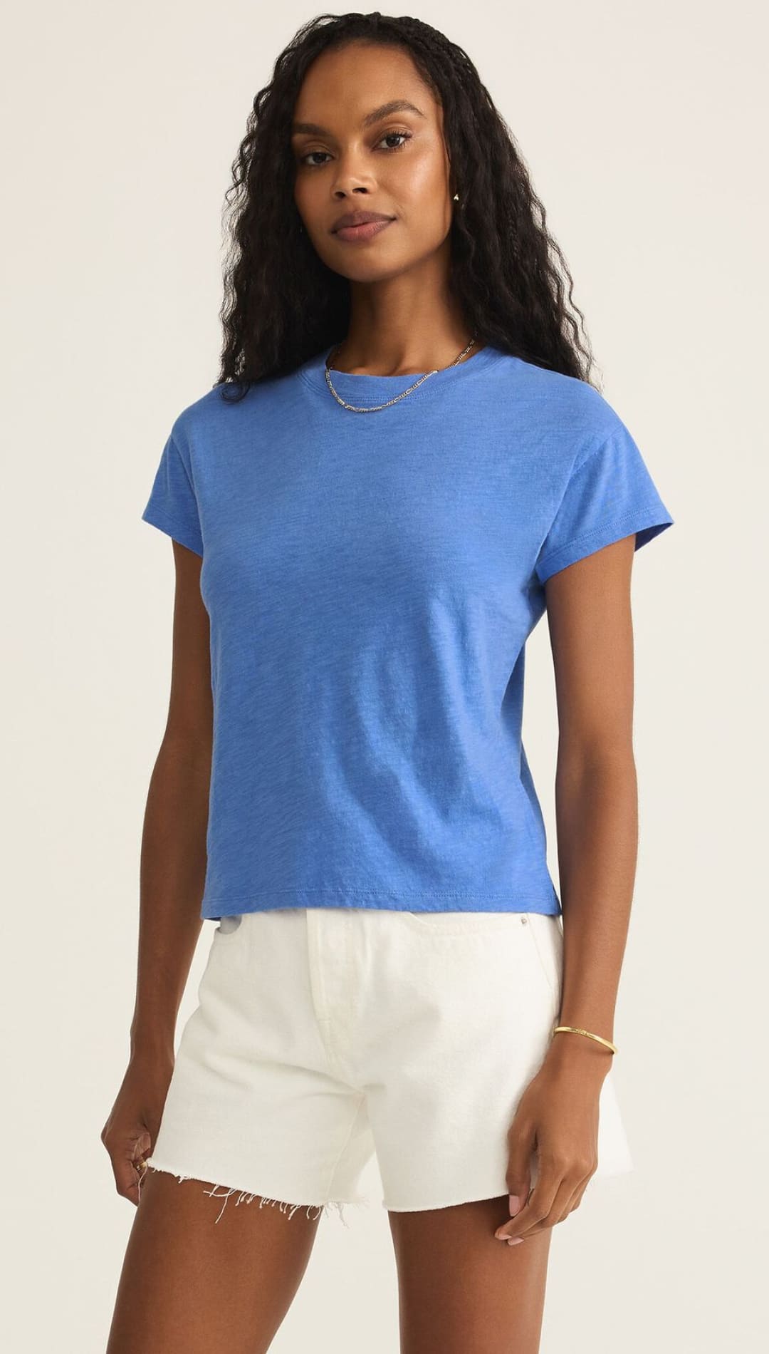 Woman wearing a blue t-shirt and white shorts.