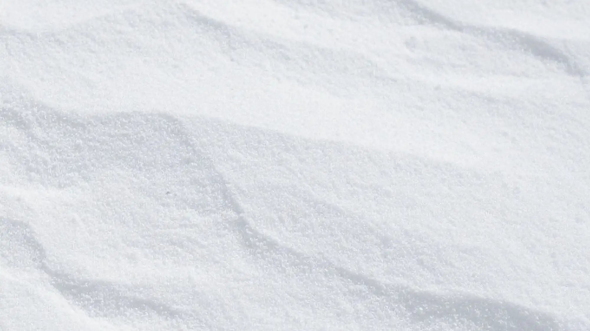 A mound of fine, crystalline white sugar with a slightly granular texture and soft ridges.