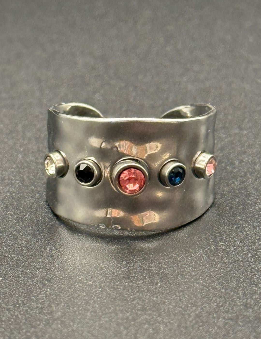 Silver ring with colorful gemstones.