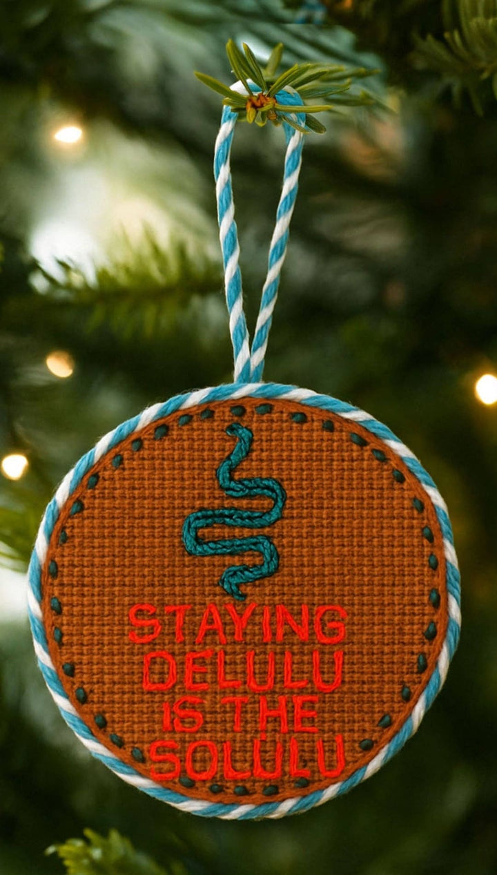 Christmas ornament with snake design, orange background and blue accents.