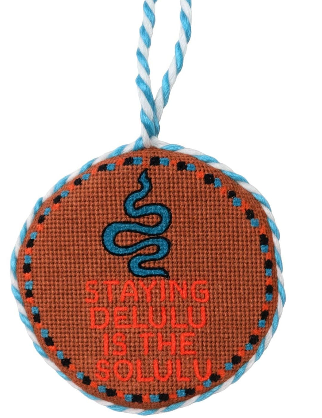 Orange cross-stitch ornament with blue snake and text ’staying cool’ on it.