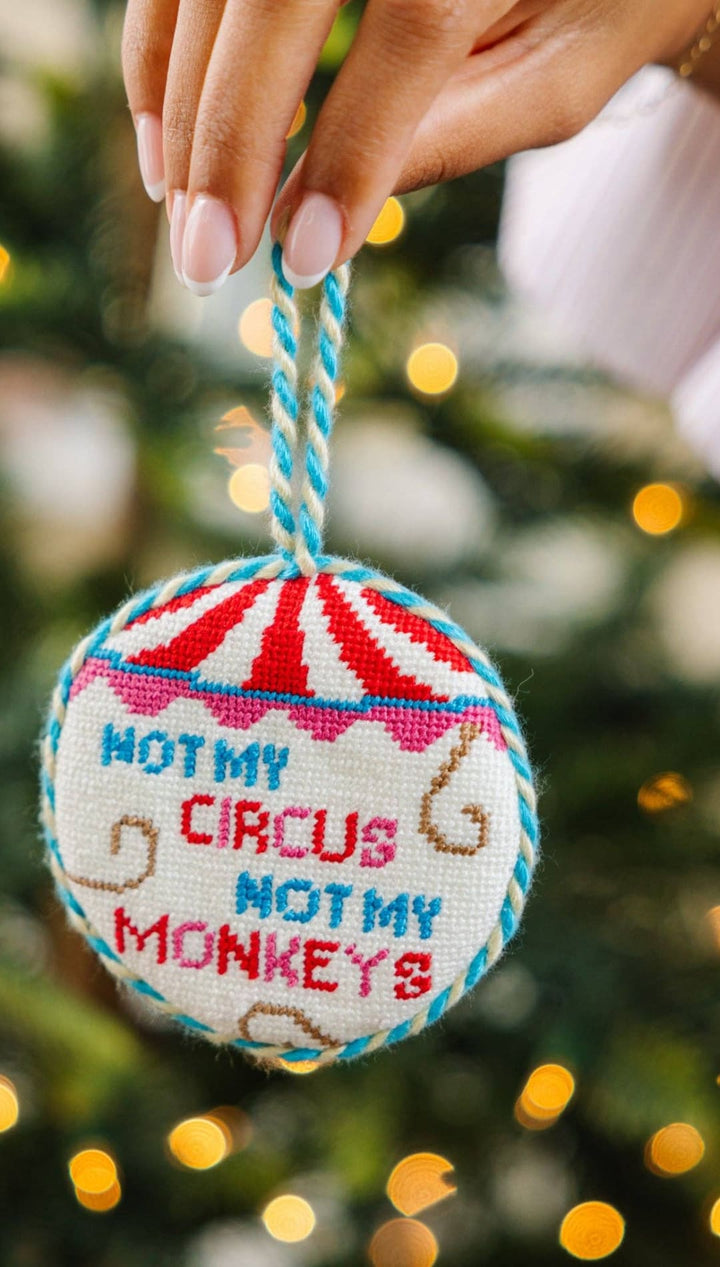 Cross-stitch ornament with ’not my circus, not my monkeys’ design on a red and white striped background.