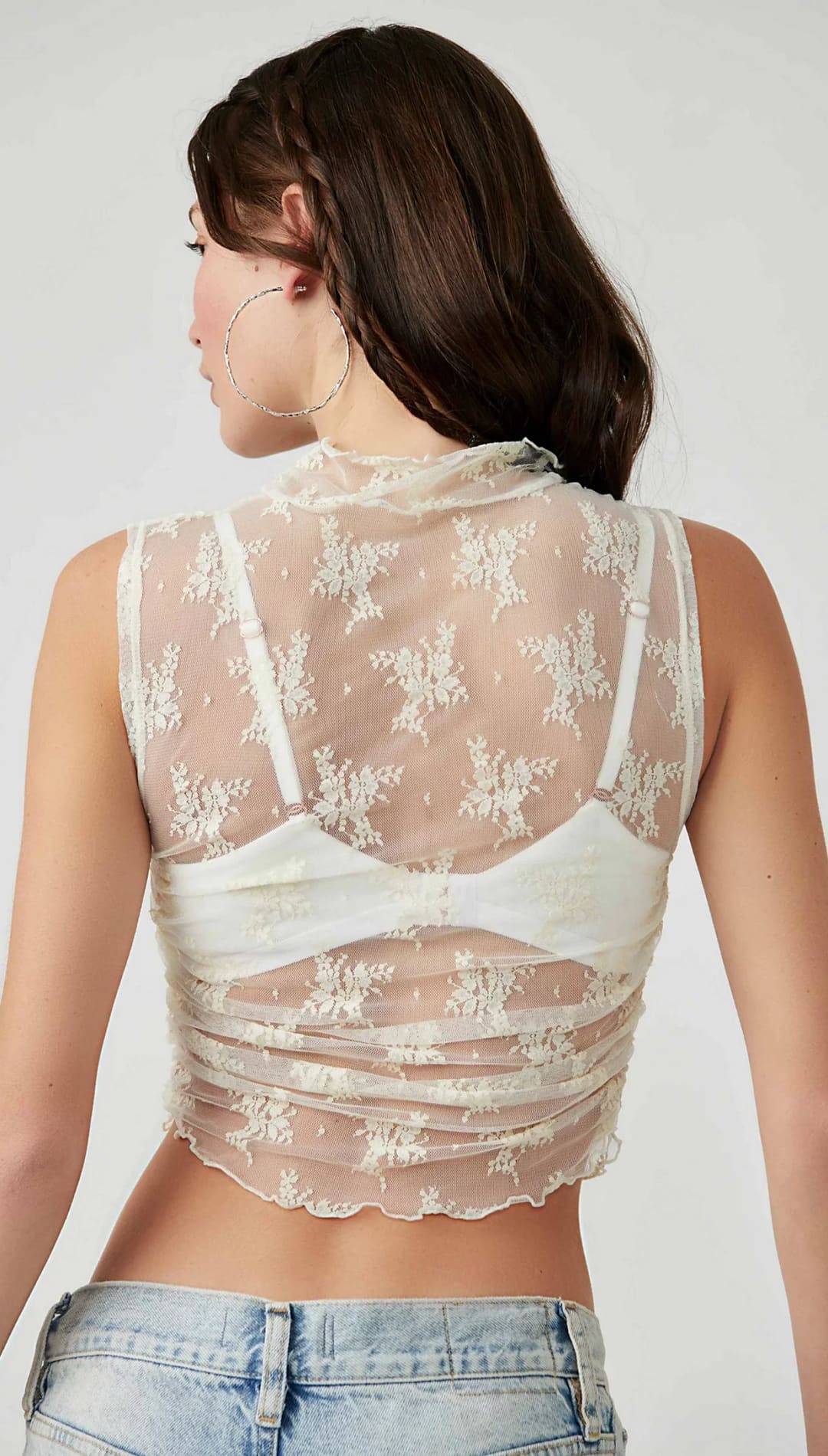 Cream lace crop top with high neckline and floral pattern.