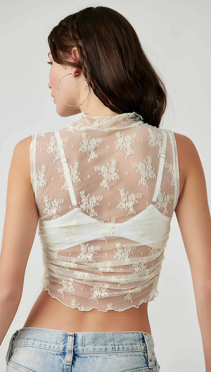 Cream lace crop top with high neckline and floral pattern.