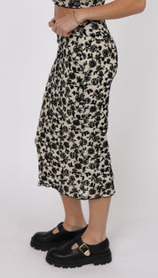 A midi-length black and white floral skirt with a ruffled hem.