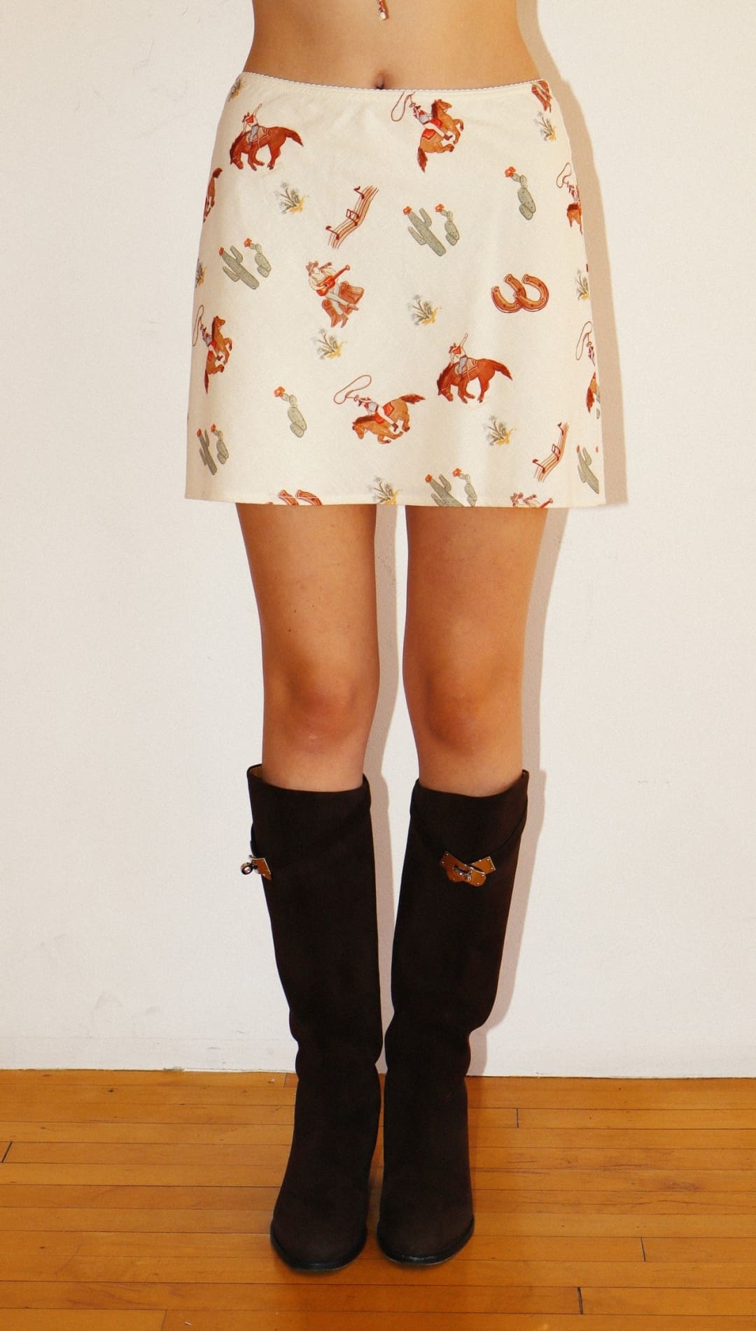 Cowboy-themed mini skirt with black knee-high boots.