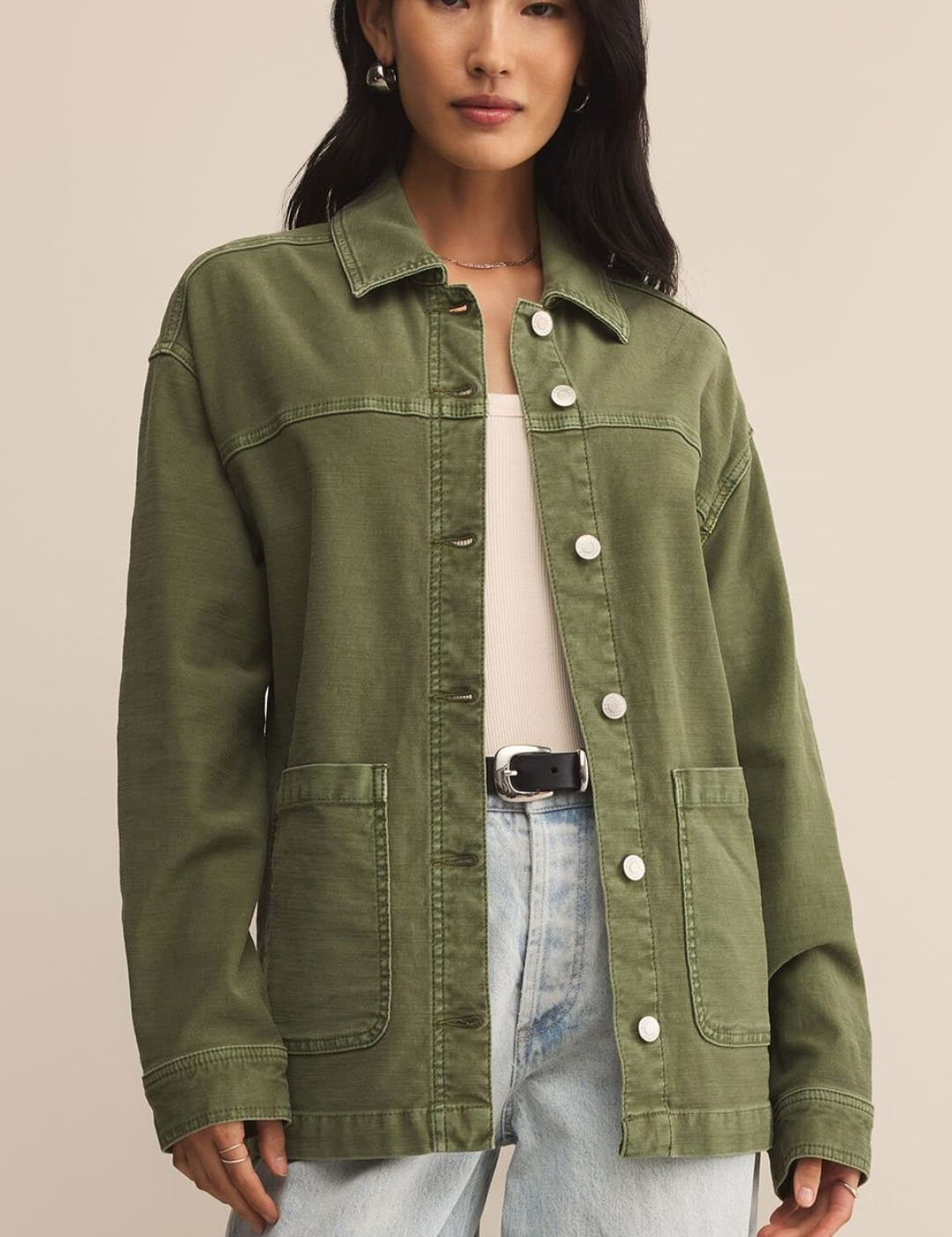 An olive green utility jacket with large buttons and front pockets.