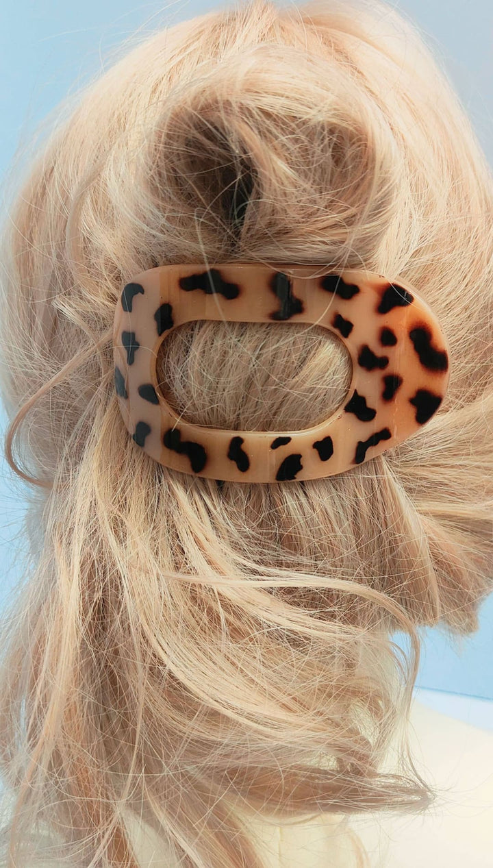 Leopard print hair clip with oval shape and textured surface.