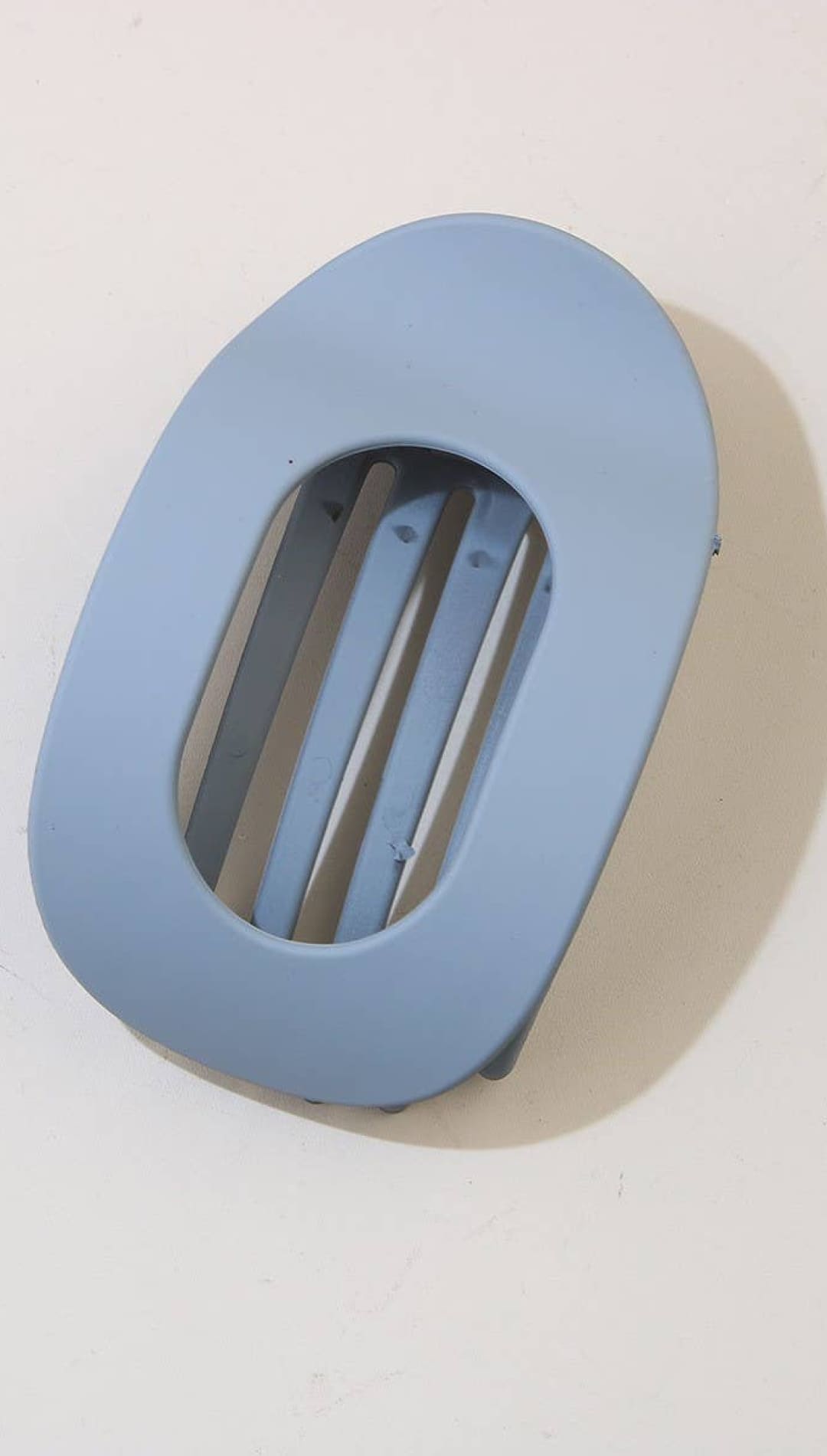 Light blue oval-shaped wall vent with horizontal slats and a smooth matte finish.